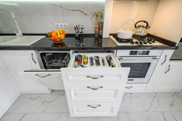 istock Luxurious white modern kitchen interior, drawers pulled out, dishwasher's door open 1311691705