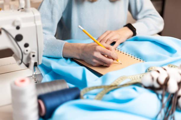 istock Draws clothing design. Workplace atelier with notepad. Tailoring order 1311692494