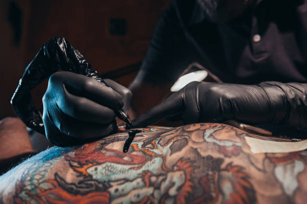 istock Tattoo artist hands creating a picture 1311695388