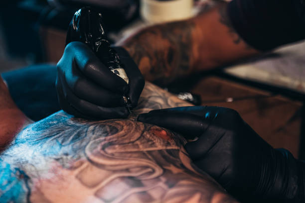 istock Tattoo artist hands creating a picture 1311695389