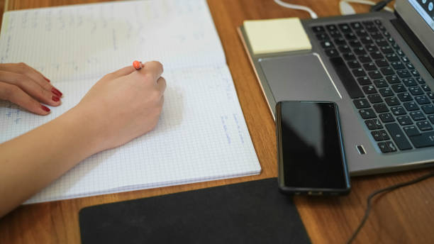 istock Woman studying at home while use notebook for remote schooling,covid-19 pandemic social distancing 1311704046
