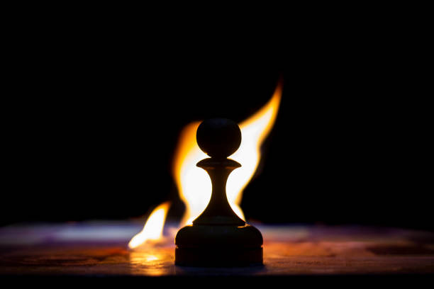 pawn on a chessboard on fire, foreground and background blurred