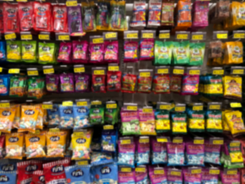 A shelf full of Brazilian brand candies in a supermarket. Blurred image