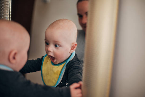 Baby boy looking at him in mirror and it's surprised him