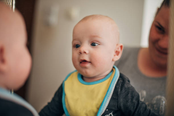 istock Baby boy looking in mirror with mom 1311708366