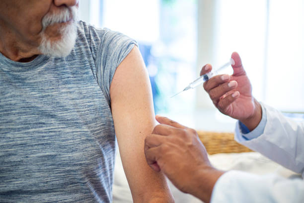 istock doctor injecting older man 1311709397
