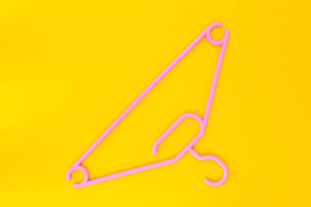 istock Pink plastic hanger on a yellow background. 1311717396