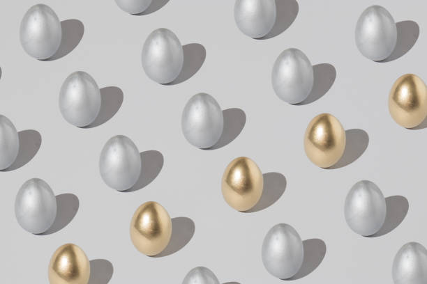istock Pattern made of silver and gold easter egg on a gray background. Minimal holiday concept. Flat lay, top view. 1311731713