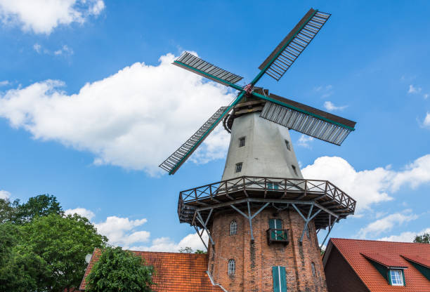 Am Wall Windmill restaurant in Bremen. Afew people are outside of restaurant. Windmill was made in 1898