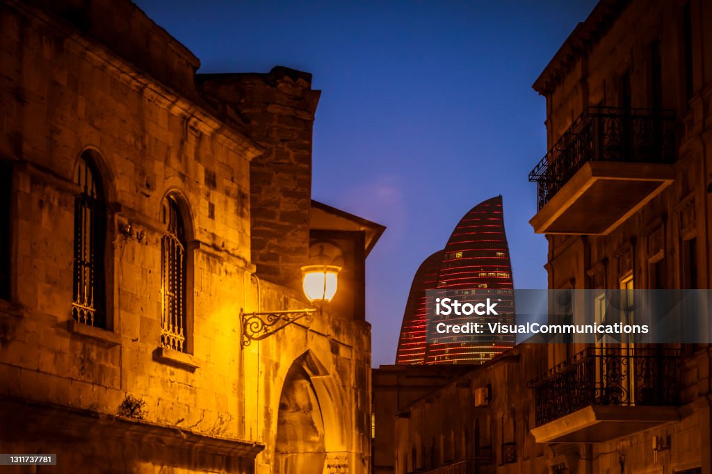 Old city in Baku at dusk with modern Flame Towers in background. Baku, capital city of Azerbaijan. Azerbaijan Stock Photo