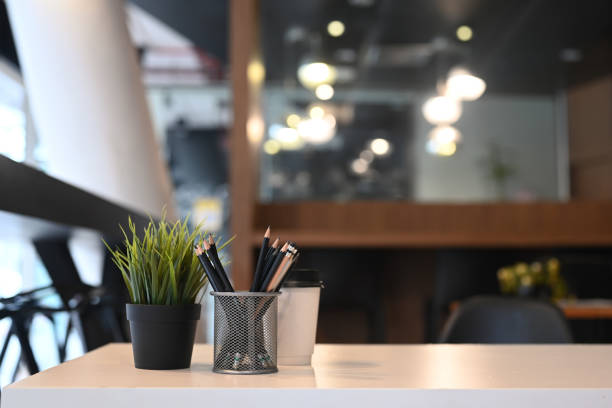 istock White office desk with pencil holder, plant and coffee cup at office interior 1311738687