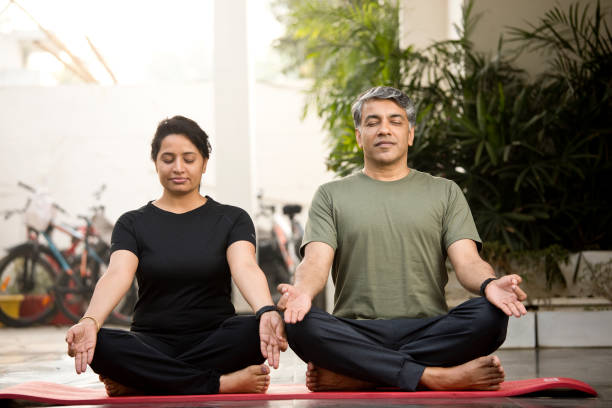 couples méditant dans la position de lotus - yoga men women exercising photos et images de collection