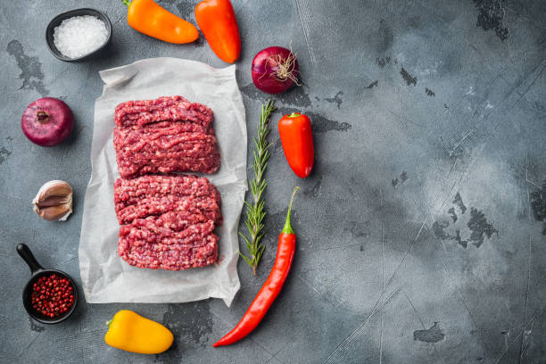 Fresh minced meat ground beef, on gray background, top view flat lay  with copy space for text