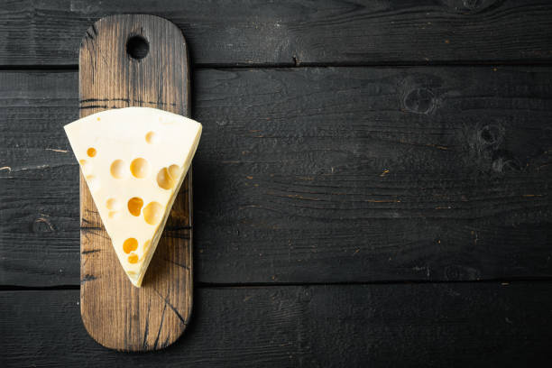 istock Maasdam cheese, on black wooden background, top view flat lay, with copy space for text 1311741337