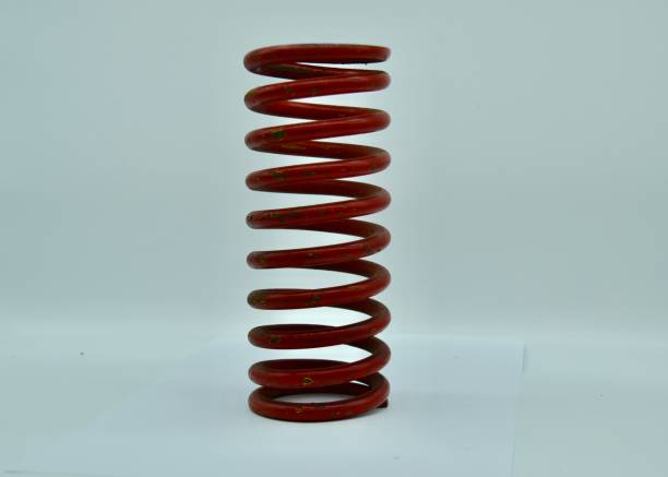 Red car or automobile steel suspension spring or coil in studio shot on white background stock photo