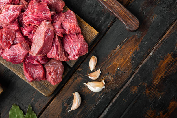 istock Fresh beef chunks served on table with ingredients ready for cooking, on old dark  wooden table , top view flat lay, with copy space for text 1311743146