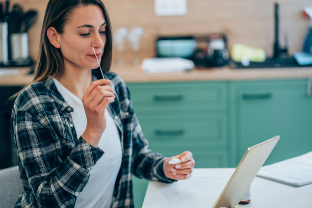 istock Woman holding self-testing  swab and rapid test for Coronavirus/COVID-19. 1311747920