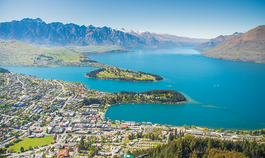 Wide angle cable car going above Queenstown and Lake Wakatipu in the Remarkable Mountains of New Zealand over residence area