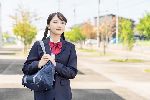 Asian female high school student commuting to school.