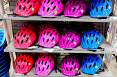 Various colors bike helmets on sport store display.