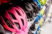 Various colors bike helmets on sport store display.