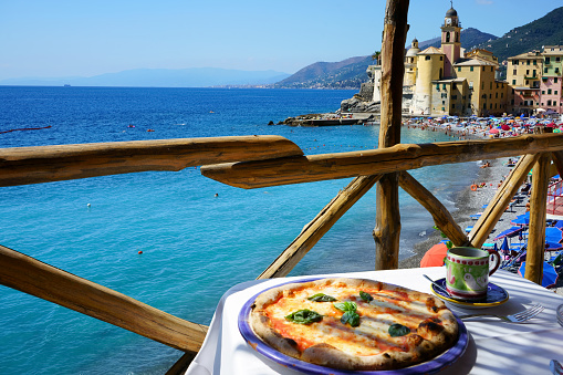 Pizza place terrace overlooking to beautiful Camogli harbor, Italian Riviera, Liguria.