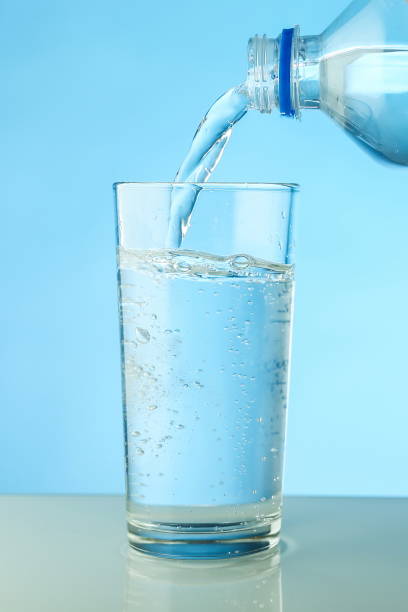 istock water is poured from a bottle into a glass close up. 1311760696