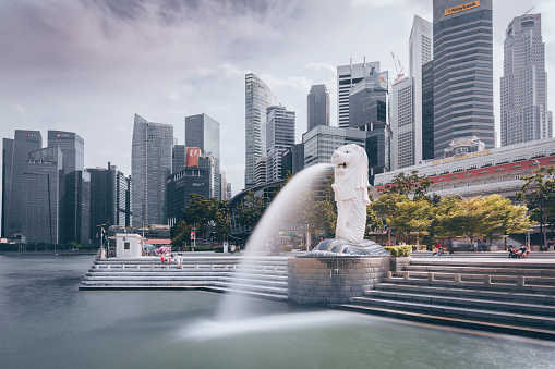 The Merlion fountain in front of the financial bank and IT district in Singapore. The Merlion is an imaginary creature with the head of a lion and a bottom of a mermaid, seen as the symbol of Singapore. Ultra high image resolution.