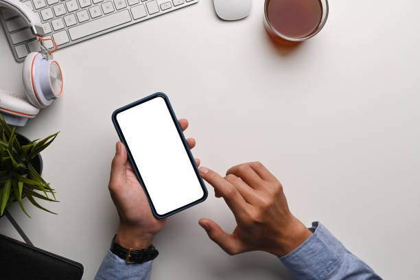 istock Above view of man holding and typing on smart phone at his workspace. 1311762270
