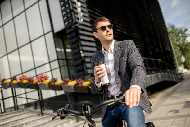 istock Young businessman on the ebike with takeaway coffee cup 1311763031