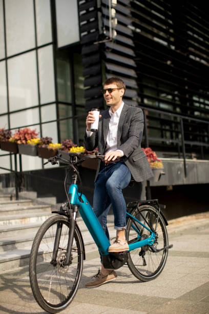 istock Young businessman on the ebike with takeaway coffee cup 1311763034