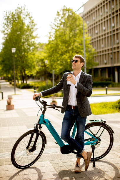 istock Young businessman on the ebike with takeaway coffee cup 1311763072
