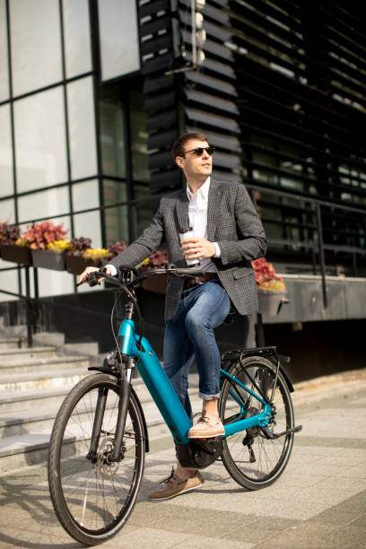 istock Young businessman on the ebike with takeaway coffee cup 1311763073