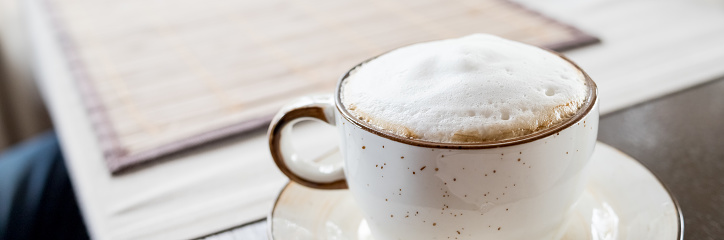 Top of view cappuccino coffee on wood table focus at white foam