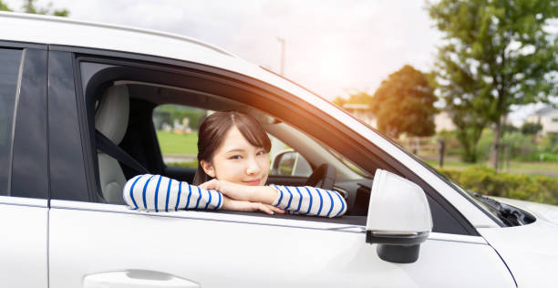 giovane donna asiatica alla guida di un'auto. - car insurance women driving foto e immagini stock