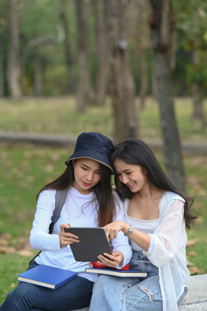 istock Two college students resting in park and chatting after lecture. 1311763330
