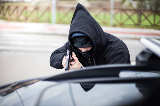 robber pointing a gun at a driver - gun handgun violence kidnapping imagens e fotografias de stock