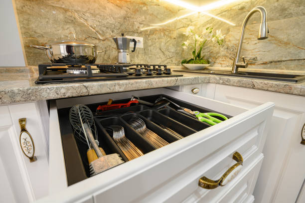 istock Drawers pulled out at modern classic white kitchen furniture 1311764680