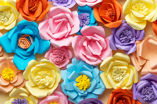 Colorful Paper Flower Arrangement on Yellow Background From Above