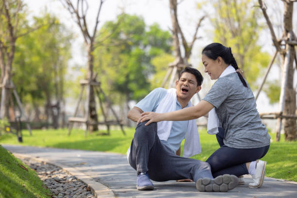 istock Asian elderly or senior man accident falling down on floor in the park while running exercise have pain knee ache. 1311766575
