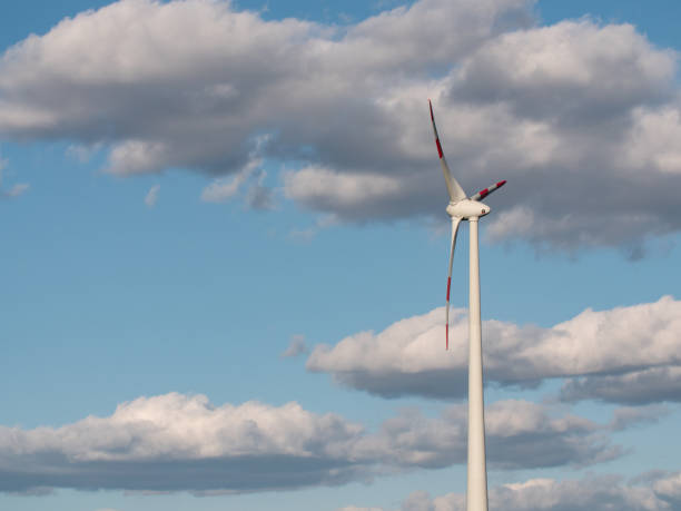 istock One wind turbine and big cumulus clouds behind the tower. 1311770446