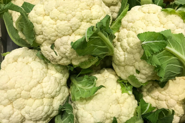 istock Cauliflowers piled on the market stall. Vegetable background 1311770983