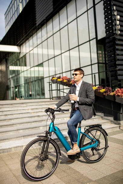 istock Young businessman on the ebike with takeaway coffee cup 1311771431