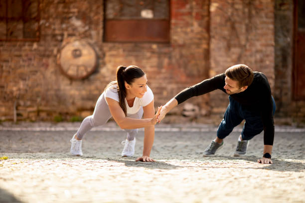 istock Young couple doung one arm pushup exercise in the urban environment 1311773237