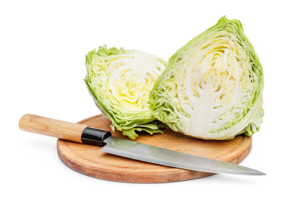 istock Halved cabbage with knife  on cutting board. Isolated on white. 1311774286