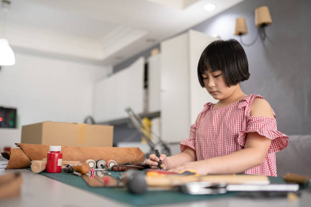 istock Asian Chinese girl learning cutting a pattern from leather 1311777734