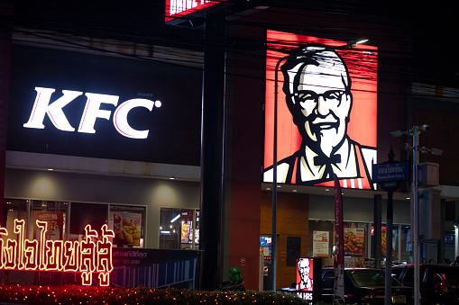 Nightshot of a KFC fast food restaurant in Bangkok Ladprao, view over junction at Wanghin Road