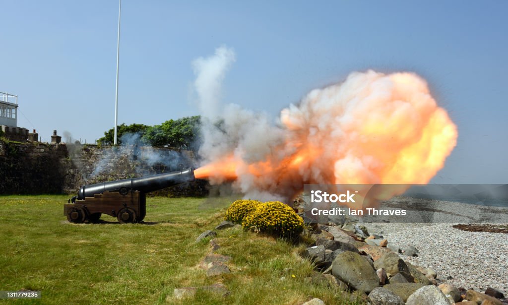 Cannon firing and showing the plume of smoke and fire , North Wales Coast, Wales, UK Historic Cannon firing at Fort Belan in Wales, UK Cannon - Artillery Stock Photo