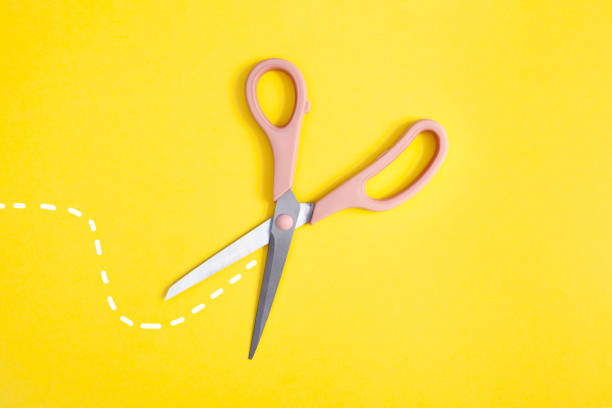 istock open pink scissors isolated on yellow background 1311779943