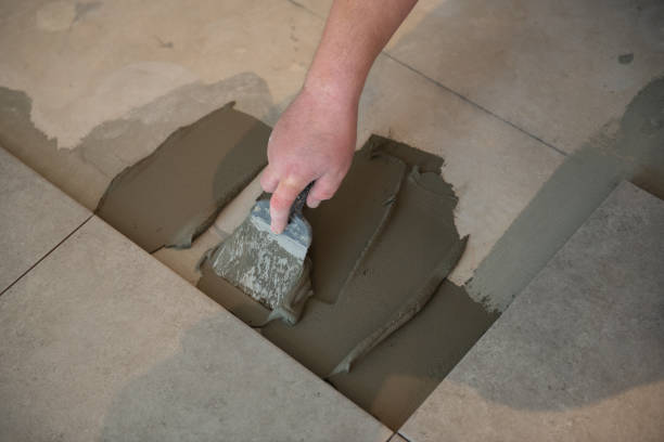 istock Tiler laying the ceramic tile on the floor. Professional worker makes renovation. Construction. Hands of the tiler. Home renovation and building new house 1311782391